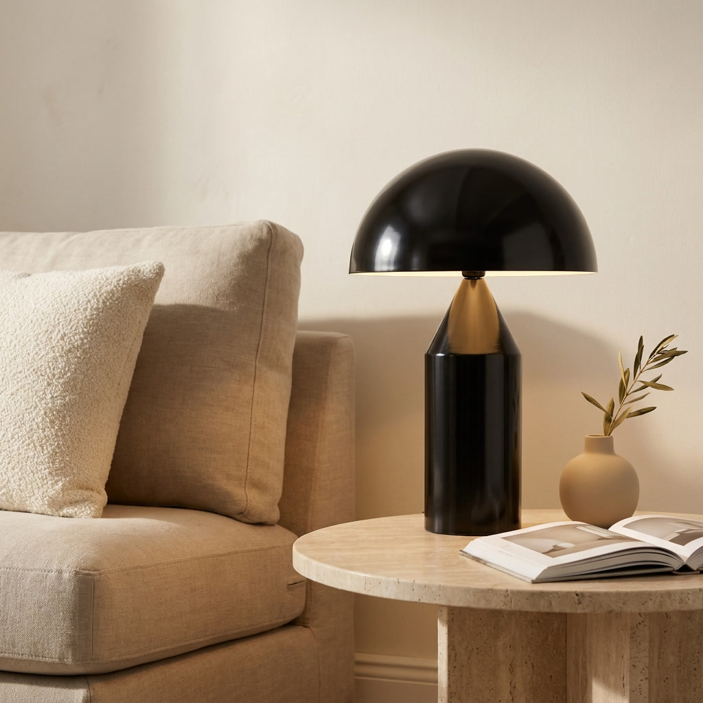 Lampe champignon noire allumée sur une table d'appoint en travertin, à côté d'un canapé en lin beige